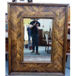 A large oak framed rectangular mirror, the beveled plate within herringbone parquetry,