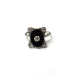 A platinum, diamond and black onyx ring, in a curved rectangular panel shaped Art Deco design,