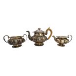 A George IV silver three piece tea set, of compressed melon fluted form,