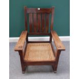 An early 20th century oak rocking chair in the manner of Gustav Stickley,