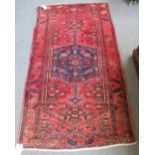 An Afghan rug, the madder field with two columns of fourteen guls, a cross border,