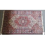 A Mazlaghan rug, Persian, the madder herate field with an ivory flowerhead,