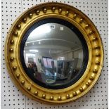 A 19th century gilt framed circular convex wall mirror with ebonised slip, 60cm wide.