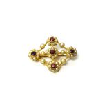 A gold, ruby and seed pearl set brooch in the form of five flowerhead shaped clusters,