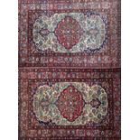 A pair of Esfahan rugs, Persian, each ivory field with a bold madder lobed medallion,