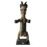 An Ogoni marionette figure, painted carved wood and cloth, on a later ebonised wooden plinth,