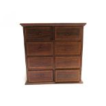 An early 20th century satinwood banded mahogany miniature chest of eight short drawers,