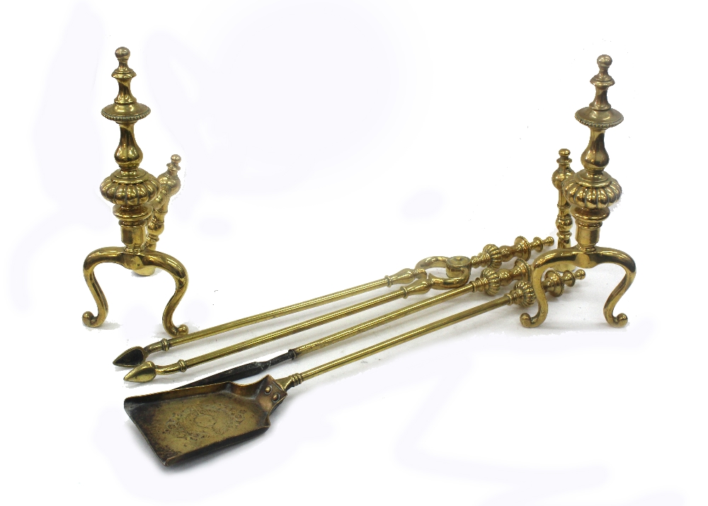 A set of 19th Century brass fire dogs and three matching fire irons with baluster and lobed finials,