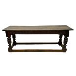 A Charles I oak refectory table, having a triple boarded cleated top, lunette carved friezes,