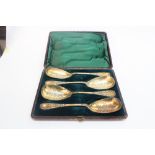A cased set of four Victorian 'Cellini' pattern gilded electroplate fruit serving spoons,