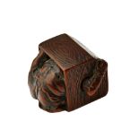 A Japanese wood netsuke of an oni hiding in a box, 19th century, signed, 2.5cm. high.