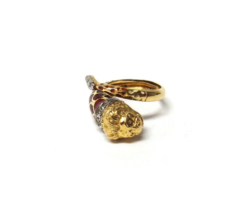 A gold, rose diamond set and red enamelled ring, in a coiled design, terminating as a lion's head,