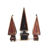 A pair of carved wooden obelisks, 19th century, gilt and red painted with spherical finial and feet,