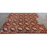 An English gross point carpet, the brown field with floral sprays of roses and lilies,