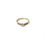 A 9ct gold and diamond set ring, claw set with the principal circular cut diamond at the centre,