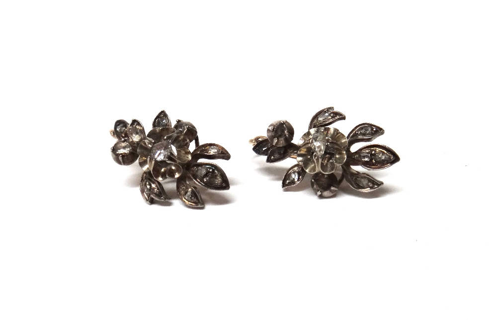 A pair of rose diamond set earrings, each in a stylized floral design,