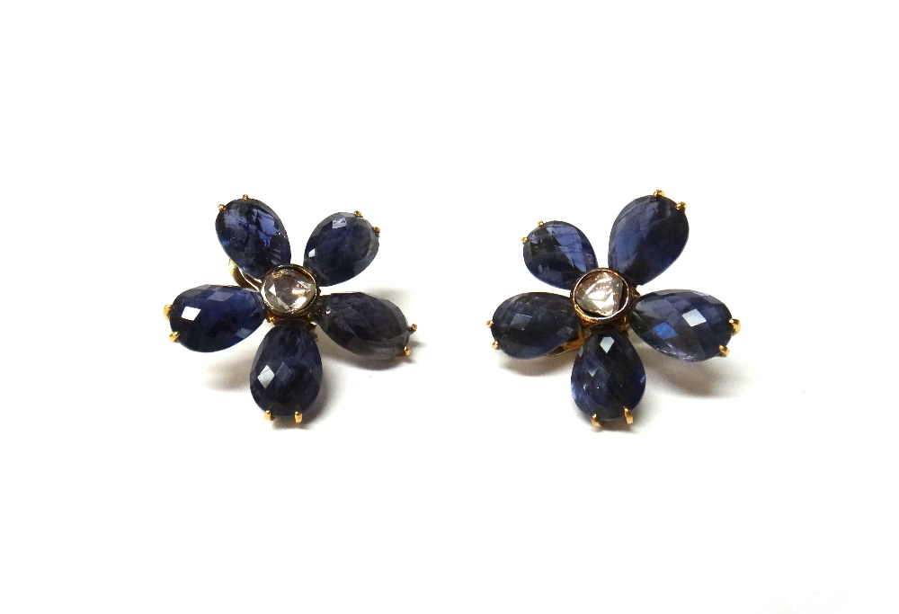 A pair of gold mounted diamond and iolite earclips, each designed as a five petal flowerhead,