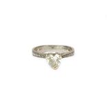 An 18ct white gold and diamond ring, claw set with the principal heart shaped diamond at the centre,