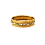 A Victorian gold and half pearl set oval hinged bangle,