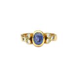 A gold, sapphire and diamond ring, mounted with the oval cut sapphire at the centre,