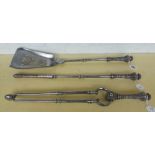 A set of Victorian steel fire irons with knopped stems and foliate cast handles,