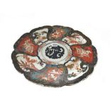 A Japanese Imari dish, Meiji period, painted with panels enclosing children, dragons,