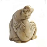 A Japanese ivory netsuke of a man standing over a sack, late 19th century, 3.75cm. high.