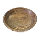 A shallow fruitwood bowl, with ring turnings to centre, 56cm diameter.