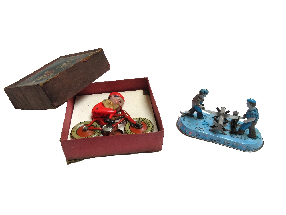 A Triang tinplate Gyro-cycle, boxed, and a tinplate wind-up lumberjack toy, 22.5cm wide (2).