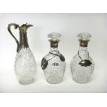 A pair of silver mounted, faceted glass decanters with stoppers, London 1931,