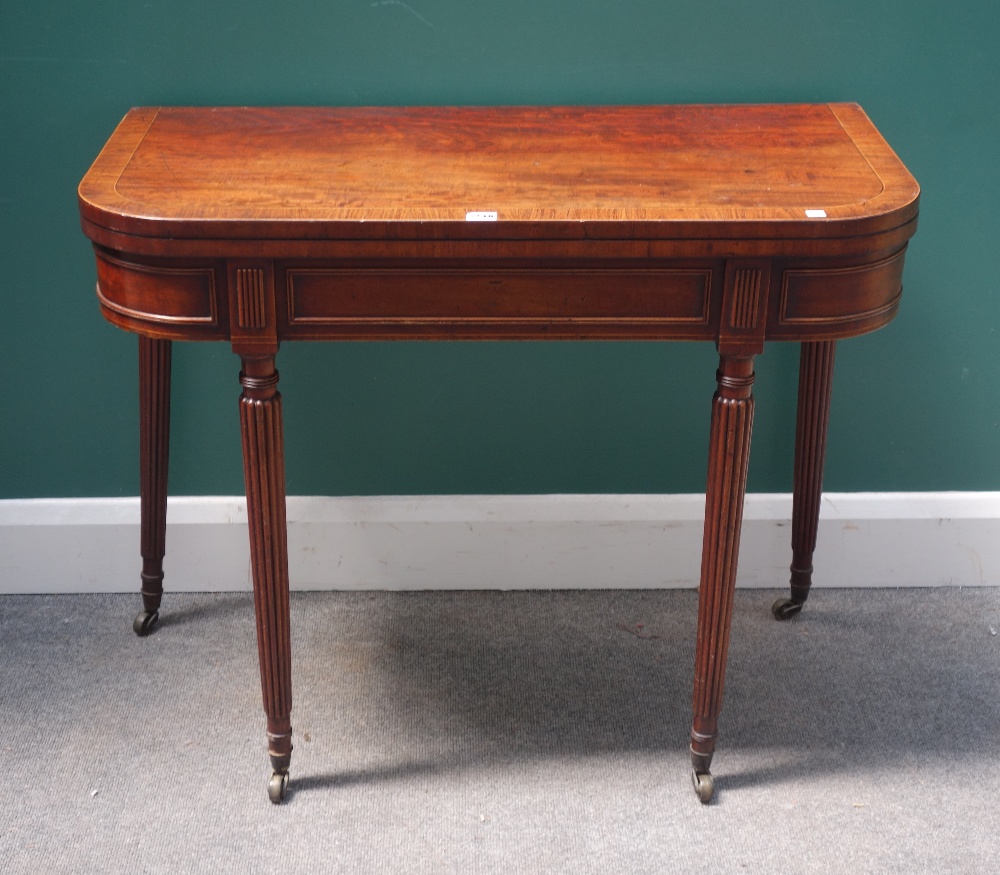 A Regency mahogany foldover card table, on tapering reeded supports, 91cm wide x 73cm high.