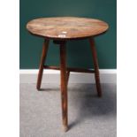 A George III oak cricket table, the circular top on three turned supports united by stretcher,