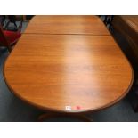 G Plan; a 20th century teak oval extending dining table on concave trestle supports,