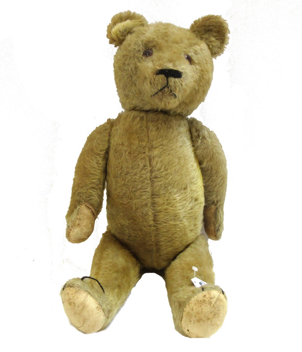 A Steiff style teddy bear, early 20th century, with golden fur and jointed limbs, 63cm.