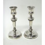 A pair of silver table candlesticks, each raised on a circular base (loaded), height 17cm,