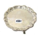 A George II silver shaped circular waiter, having a pie crust rim with scalloped motifs,