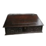 An 18th century oak slope front box, with carved front panel and fitted interior,