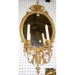 A Victorian gilt gesso oval wall mirror, with twin branch candle sconce 41cm wide x 81cm high.