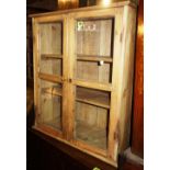 A pine hanging glazed two door wall cabinet, 60cm wide.