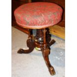 A Victorian circular walnut height adjustable piano stool, on three downswept supports, 33cm wide.
