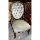 A Victorian walnut nursing chair with oval buttoned back.