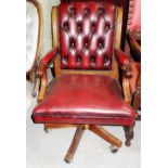 A 20th century mahogany framed open arm office swivel chair.