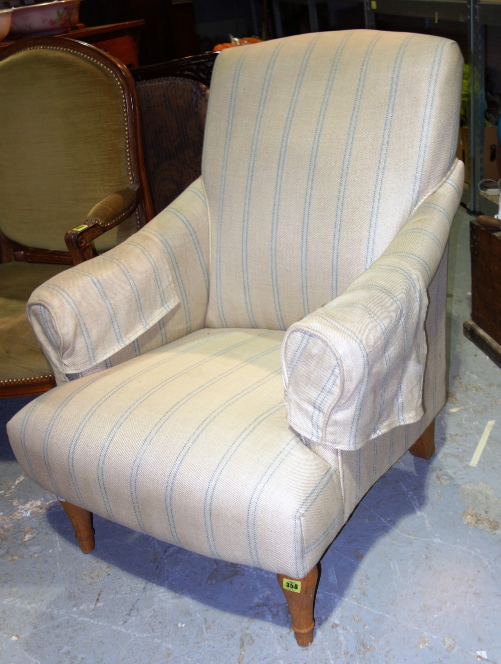 A 20th century oak framed, cream and blue striped upholstered armchair.