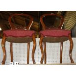 A pair of Victorian walnut framed balloon back dining chairs, with carved waist rail (2).