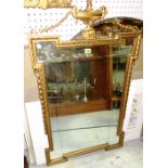 A 20th century gilt framed rectangular mirror, with ribbon and urn surmount.