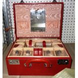 A 20th century red leather vanity case and part contents.