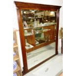 An early 20th century oak rectangular overmantel mirror with bevelled plate,