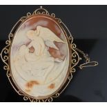 An oval shell cameo brooch depicting an angel attending a Neoclassical female lying in a crescent