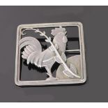 A Georg Jensen silver brooch 'Rooster at sunrise' designed by Arno Malinowski within a square frame,