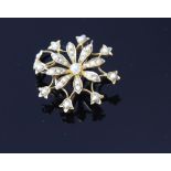 An Edwardian gold and seed pearl pendant brooch, formed as an eight petalled flower, un-marked,